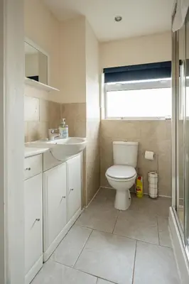a bathroom with a toilet and a sink and a window at 3-Bed Home Near Town Center in Stirling