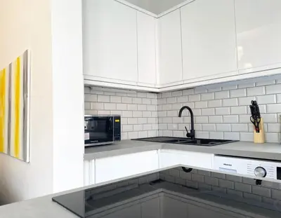 a white kitchen with a sink and a microwave at Renovated West End Flat in Glasgow in Glasgow