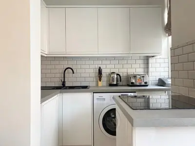 a white kitchen with a washing machine in it at Renovated West End Flat in Glasgow in Glasgow