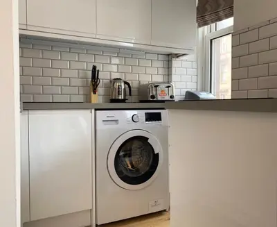 a kitchen with a washing machine in a kitchen at Renovated West End Flat in Glasgow in Glasgow
