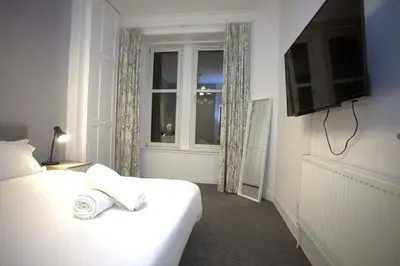 a hotel room with a bed and a window at Renovated West End Flat in Glasgow in Glasgow