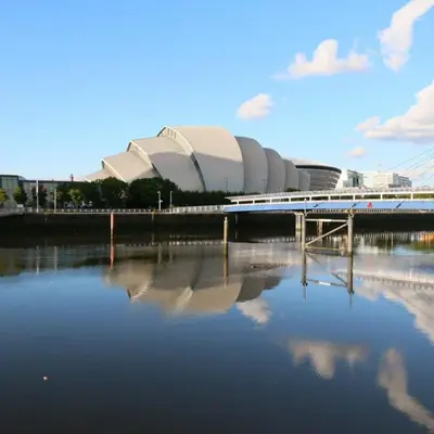 a bridge over a body of water in front of a stadium at Renovated West End Flat in Glasgow in Glasgow