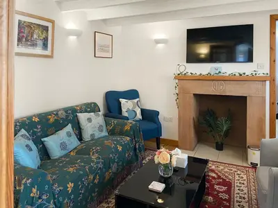 a living room with a couch and a fireplace at Cosy Cottage in Lamlash