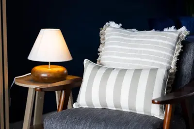 a chair with a pillow and a lamp on a table at Charming Terrace House for Relaxing Retreat in Dumbarton
