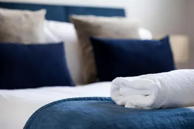 a white towel sitting on top of a bed at Charming Terrace House for Relaxing Retreat in Dumbarton