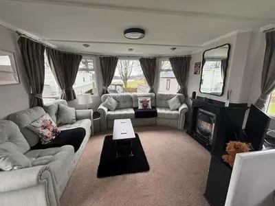 a living room with couches and a fire place at No 38 Heilan Hoose at Three Lochs Newton Stewart in Newton Stewart