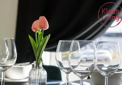 four wine glasses on a table with a vase with flowers at Orbiston House by Klass Living Bellshill in Bellshill