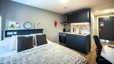 a bedroom with a bed and a sink and a clock at For Students Only Clyde Court Glasgow in Glasgow
