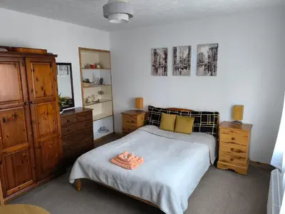 a bedroom with a bed and a dresser at Rustic Harmony - Edinburgh Airport near, 8mi in Rosyth