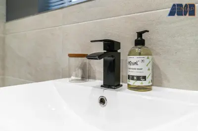 a bottle of liquid soap sitting next to a bathroom sink at 3Bed Home Sleeps 6 w Private Parking in Dunfermline