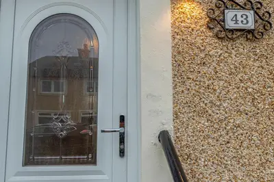 a door with a number on it next to a building at Vacant Nests The Grampian Free Wifi in Wishaw
