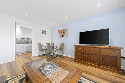 a living room with a flat screen tv and a table at Slateford 2 Bedroom Apartment - Edinburgh in Edinburgh