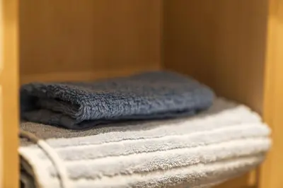 a stack of towels sitting on a shelf at Slateford 2 Bedroom Apartment - Edinburgh in Edinburgh
