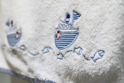 a close up of thedetail of a white pillow with a boat on it at Slateford 2 Bedroom Apartment - Edinburgh in Edinburgh