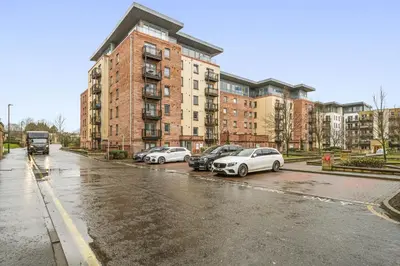 three cars parked in a parking lot in front of a building at Slateford 2 Bedroom Apartment - Edinburgh in Edinburgh