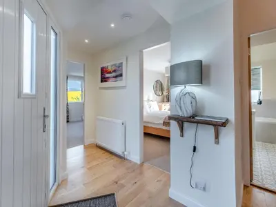 a hallway of a bedroom with a bed and a lamp at Newbigging Farm Cottage in Auchterarder