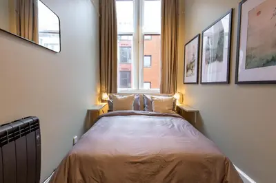 a bed in a room with two windows at Quiet City Centre, King & Sofa Bed in Glasgow