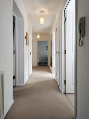 a hallway of a home with white walls and a hallwayngth at Pilmuir Apartment 3 bed 2 bath in Dunfermline