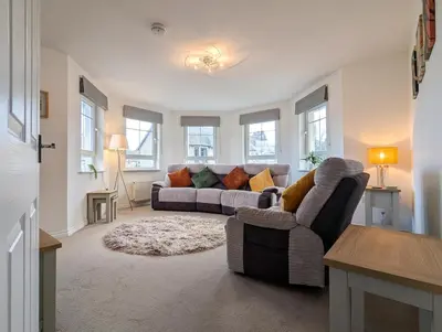 a living room with a couch and a chair at Pilmuir Apartment 3 bed 2 bath in Dunfermline