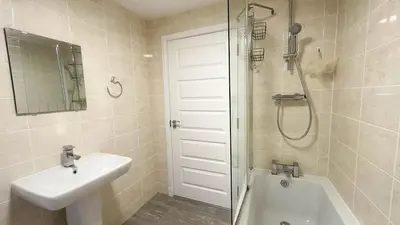 a white bathroom with a sink and a shower at Modern Main Door Flat Edinburgh City Center in Edinburgh