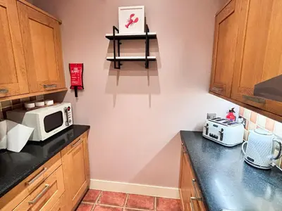 a kitchen with a microwave and a counter top at Glasgow City - Large Stylish 2 Bed Flat in Unique Ibrox Location Walking Distance to Subway and Free On-Street Parking in Glasgow