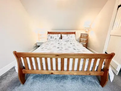 a bedroom with a wooden bed in a room at Traditional Inveraray Cottage - Amazing Loch Views in Inveraray