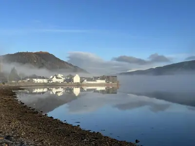 a large body of water with houses on the shore at Traditional Inveraray Cottage - Amazing Loch Views in Inveraray