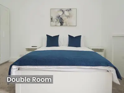 a bedroom with a large bed with blue sheets at Edinburgh Modern Apartment in Haymarket, city centre in Edinburgh