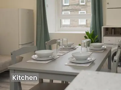 a dining room table with bowls and plates on it at Edinburgh Modern Apartment in Haymarket, city centre in Edinburgh