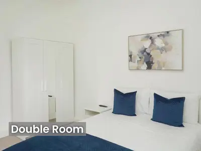 a bedroom with a white bed with blue pillows at Edinburgh Modern Apartment in Haymarket, city centre in Edinburgh