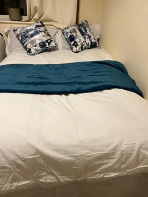 a white bed with blue and white sheets and pillows at IFYLOVESITt2 in Moffat