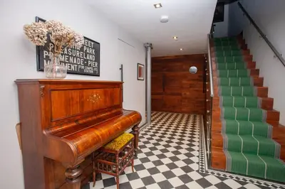 a piano in a room with a checkered floor at Unique House in Park District in Glasgow