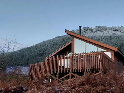 a wooden cabin on a hill with a forest at Strathyre, Ben Ledi Cabins - Forest Holidays in Callander