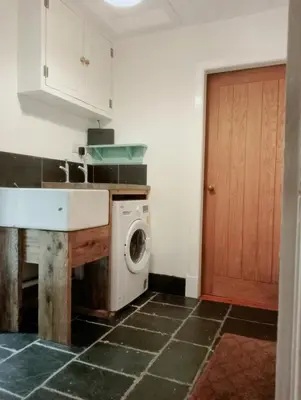 a kitchen with a sink and a washing machine at Red Deer Cottage at Fanans in Oban