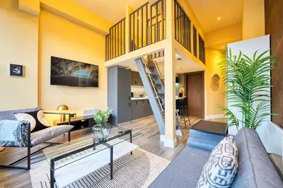 a living room with yellow walls and a staircase at Union Court Mezzanine - B9 - Building has no lift and stairs to all apartments in Glasgow