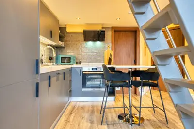 a kitchen with a table and some chairs in it at Union Court Mezzanine - B9 - Building has no lift and stairs to all apartments in Glasgow
