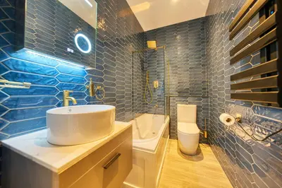 a blue tiled bathroom with a sink and a toilet at Union Court Mezzanine - B9 - Building has no lift and stairs to all apartments in Glasgow