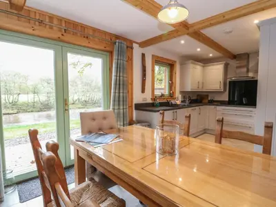 a kitchen with a wooden table and a large window at Bradan Lodge in Dalmally
