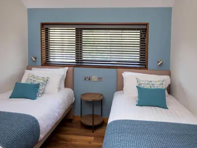 two beds in a room with blue walls and a window at Ardgartan Argyll Cabins - Forest Holidays in Arrochar
