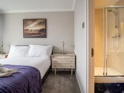 a bedroom with a bed and a shower at Metropolitan St Andrews Cathedral View - Pass the Keys in Glasgow