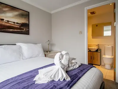 a bedroom with a bed with a towel animal on it at Metropolitan St Andrews Cathedral View - Pass the Keys in Glasgow