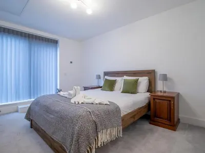 a bedroom with a large bed and a window at Fabulous Festival Park Home Private Parking Garden - Pass the Keys in Glasgow