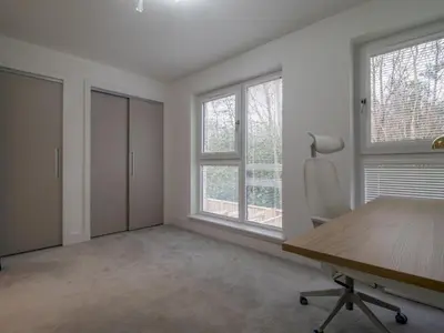 an empty office with a wooden desk and windows at Fabulous Festival Park Home Private Parking Garden - Pass the Keys in Glasgow