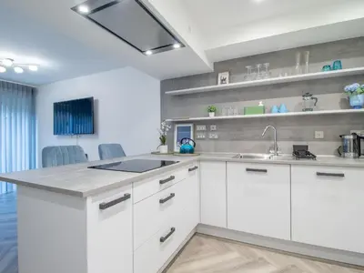 a kitchen with white cabinets and a sink at Fabulous Festival Park Home Private Parking Garden - Pass the Keys in Glasgow