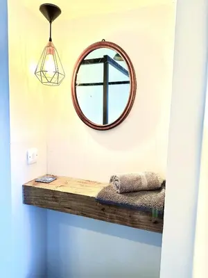 a mirror hanging on a wall next to a shelf at Cherry Trees in Inveraray