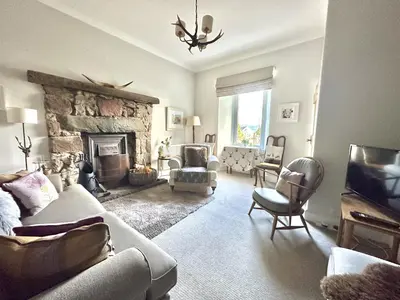a living room with a couch and a fireplace at Cherry Trees in Inveraray