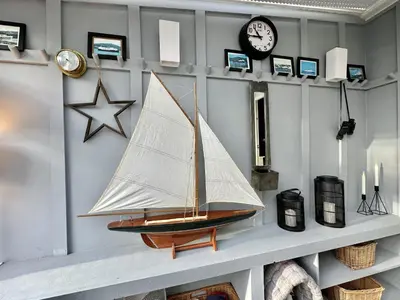 a model sailboat on a shelf with a clock at Cherry Trees in Inveraray