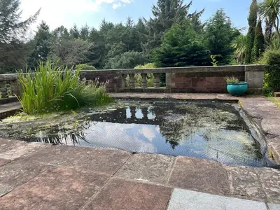 a pond in the middle of a garden at Lovely Carlung House in West Kilbride