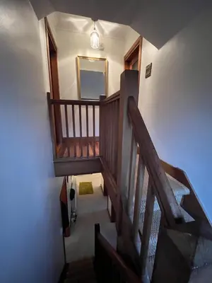 a wooden staircase in a house with a mirror at Lovely Carlung House in West Kilbride