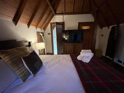 a bedroom with a bed with two pillows and a television at Lovely Carlung House in West Kilbride